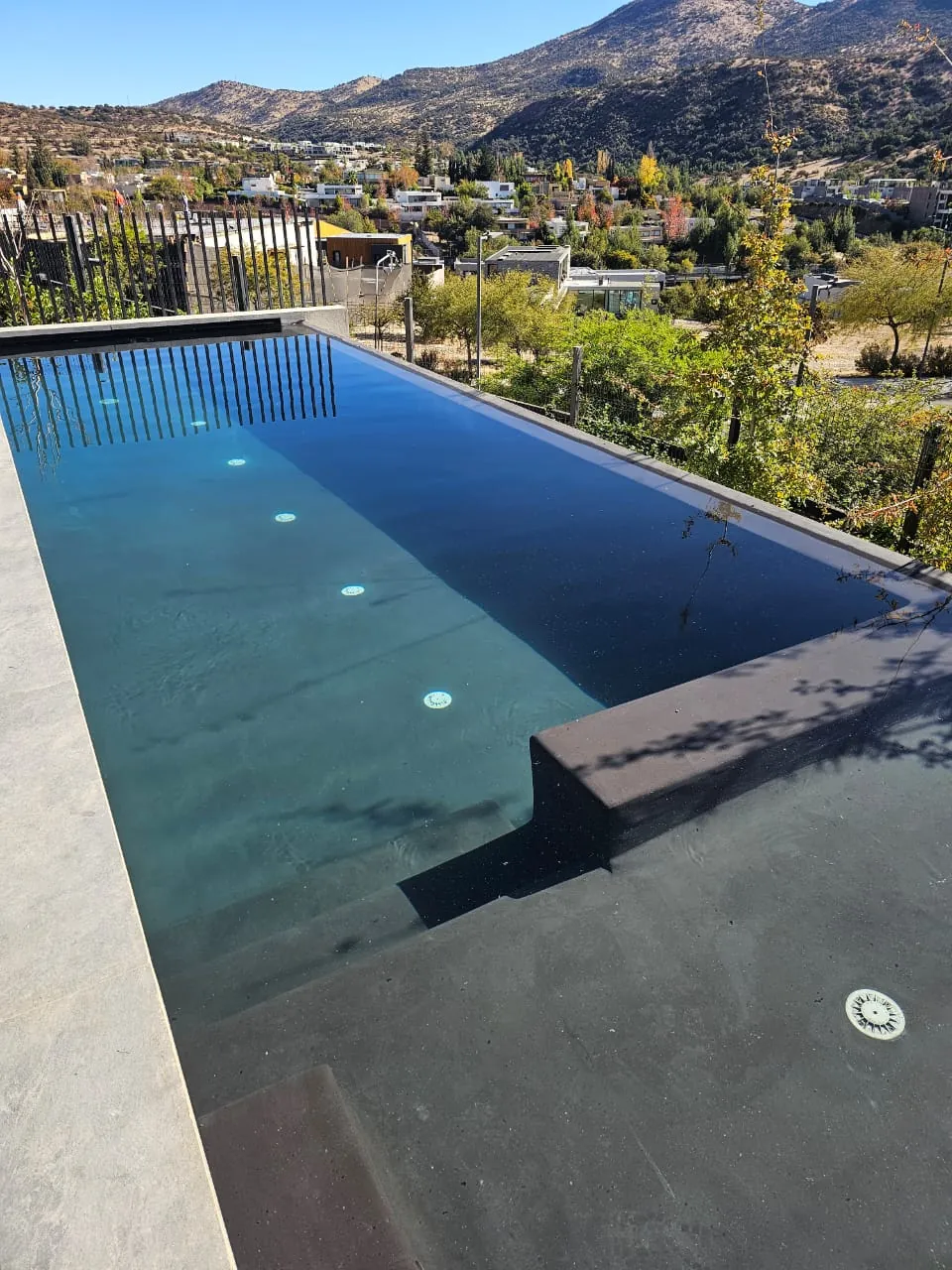 Detalle de terminaciones y luces LED de piscina premium con vista panorámica, construcción Smartpiscinas