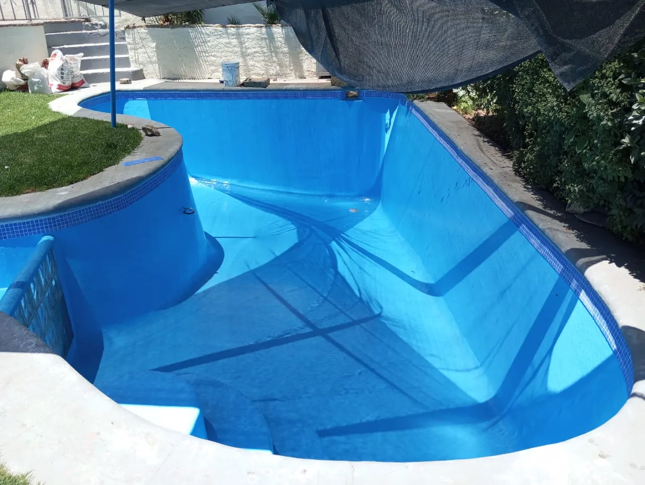 Vista general de piscina renovada con fibra y pintura