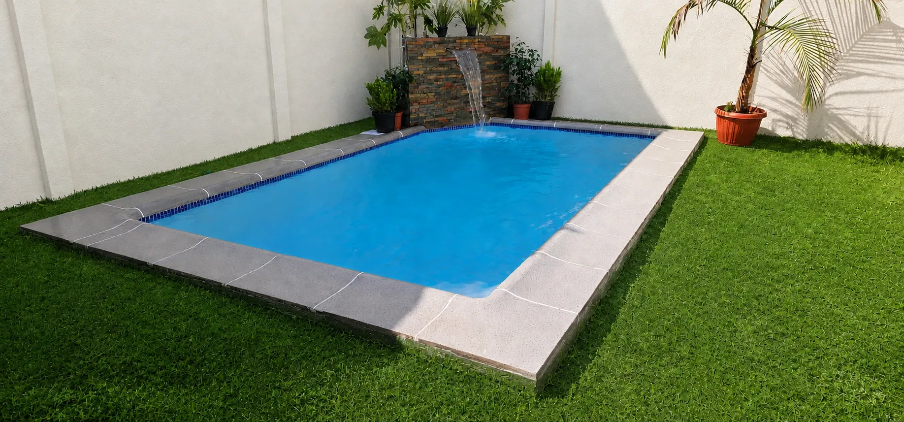 Piscina residencial terminada con césped y cascada de piedra, trabajo realizado por Smart Piscinas